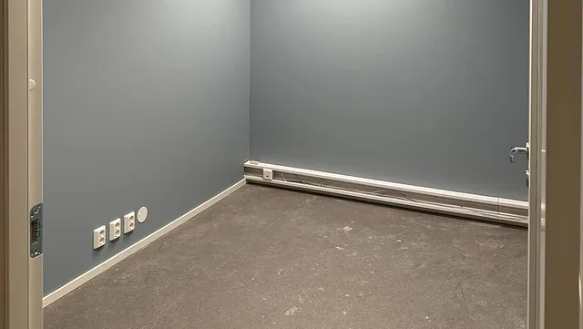 Lite tomt rom med blå vegger og taklys.